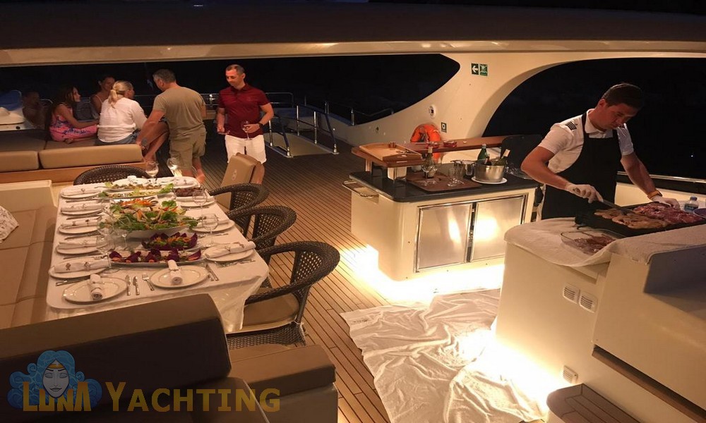 Exterior dining area on the Merve Luxury Motor Yacht in the Aegean Sea with passengers and a chef on deck